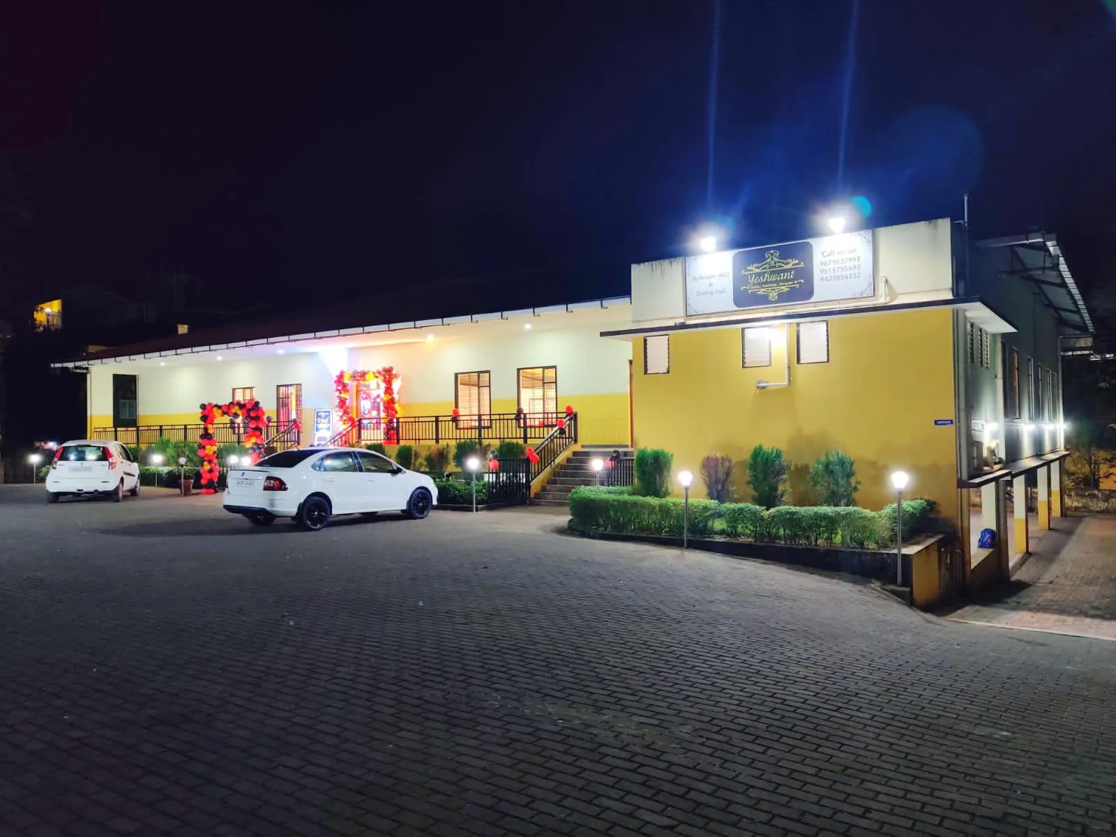 Yeshwant Hall building and parking area lit up at night
